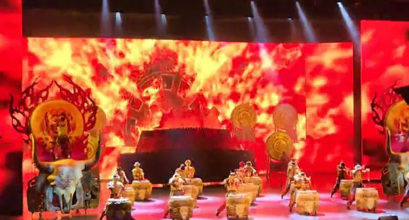 Percusionistas en el escenario interior de Charming Xiangxi iluminado de rojo