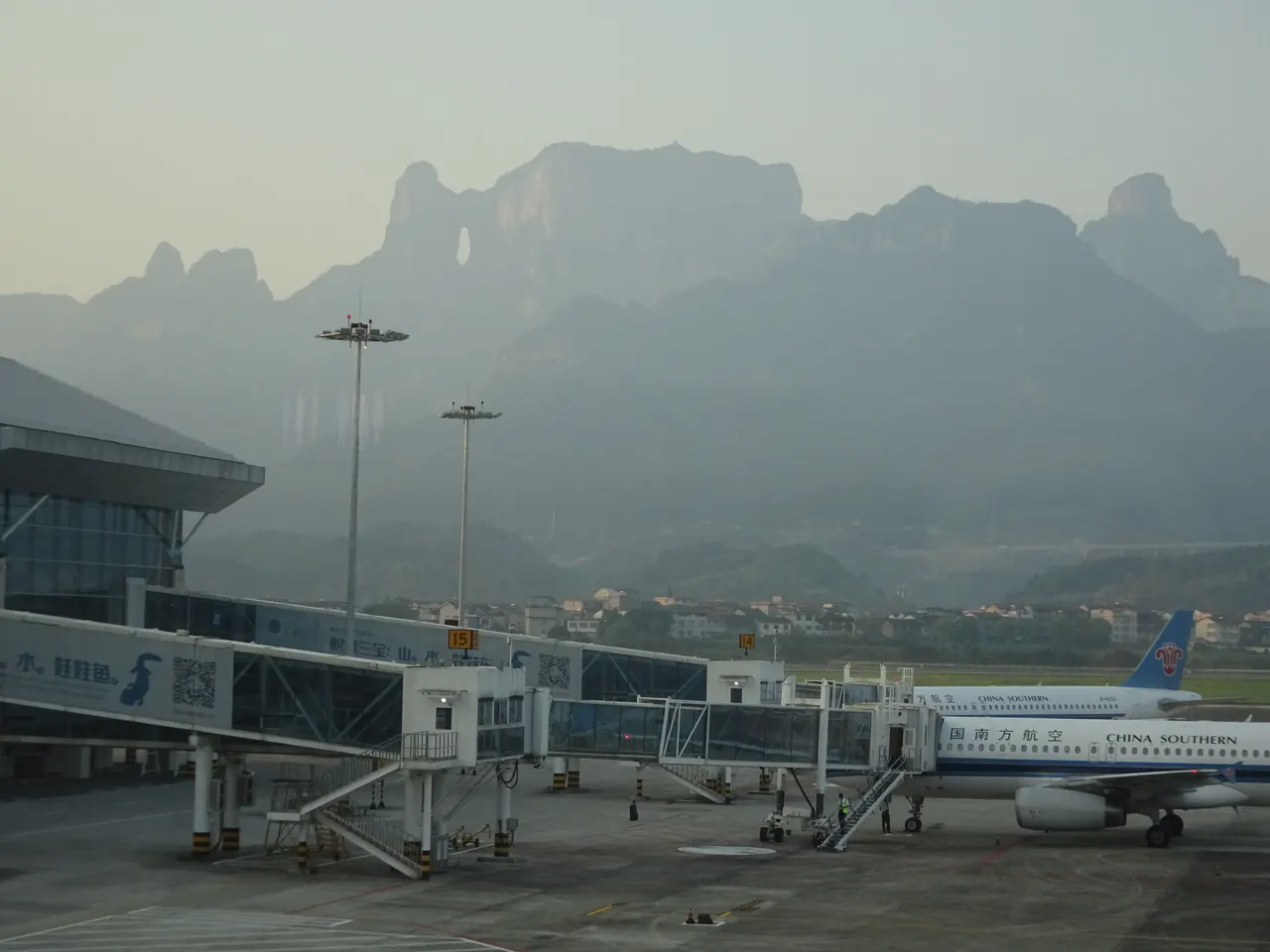 Aerei e pontili d’imbarco all’aeroporto di Zhangjiajie Hehua, con il monte Tianmen sullo sfondo, nel 2018