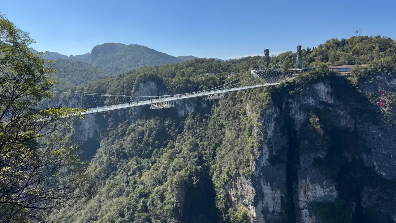 The Glass Bridge spans forested cliffs above Zhangjiajie Grand Canyon