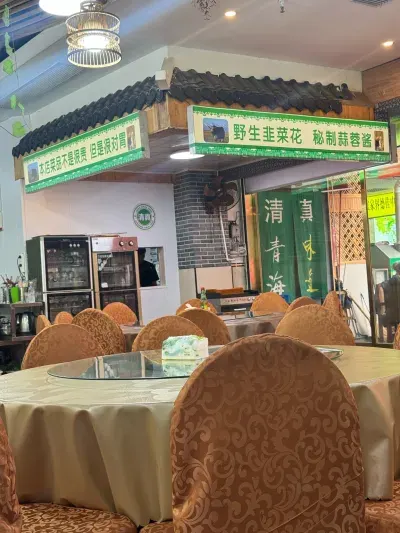 Tavoli rotondi e insegne halal nel ristorante 清真青海味道马氏烧烤炒菜面食
