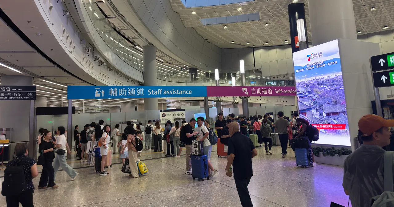 Travelers with luggage below staff-assistance and self-service signs in Hong Kong West Kowloon's departure hall, August 2026