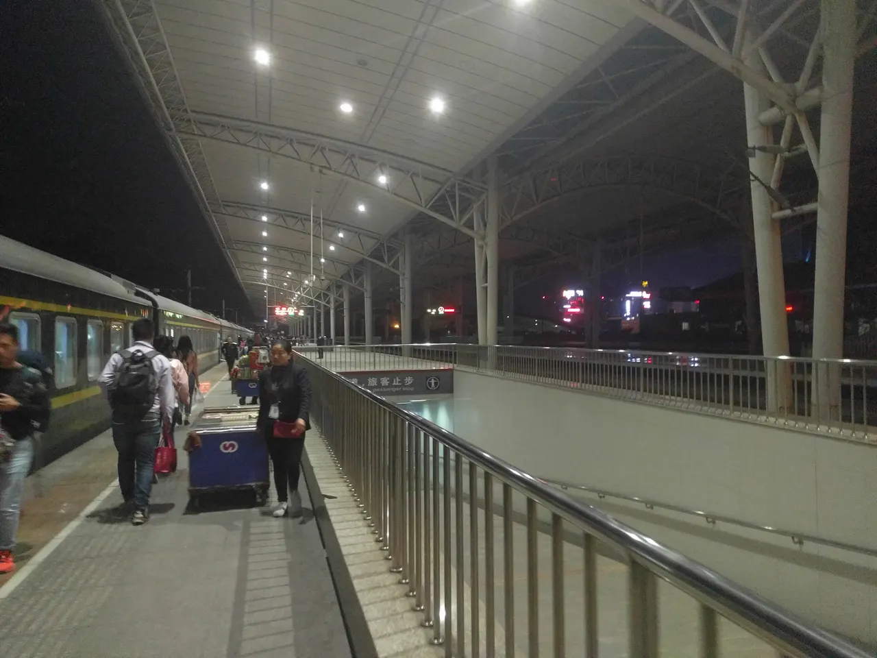 Viaggiatori accanto a un treno sul binario coperto di Zhangjiajie di notte