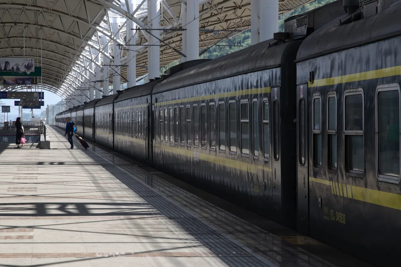 Viaggiatore con valigia a rotelle sulla banchina della stazione di Zhangjiajie nell’ottobre 2016