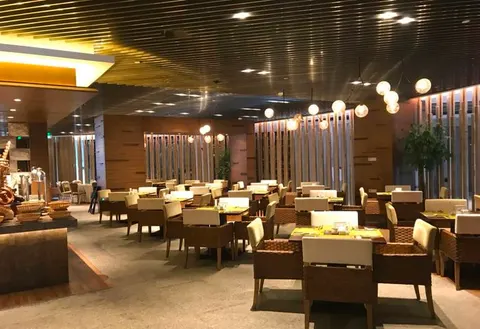 Mesas y sillas bajo lámparas colgantes en un restaurante del hotel Neodalle
