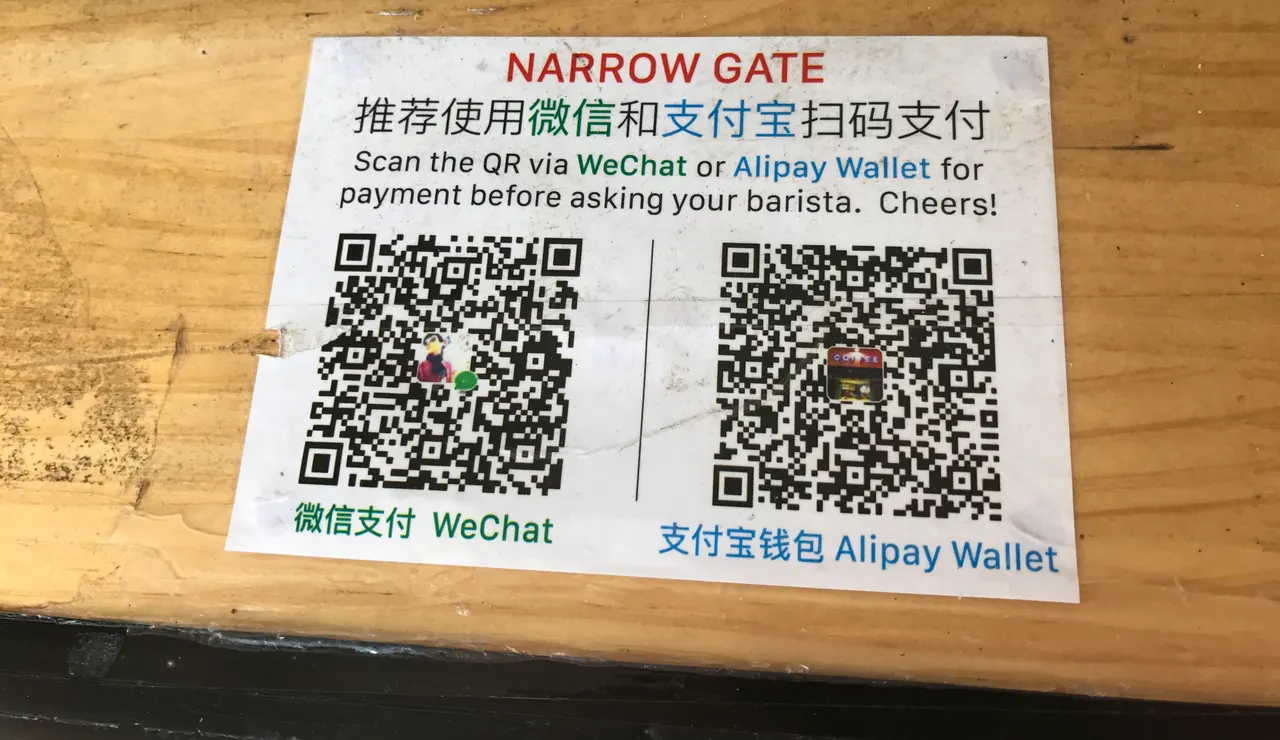 Códigos QR de pago de WeChat y Alipay en el mostrador de una cafetería, fotografiados en 2017