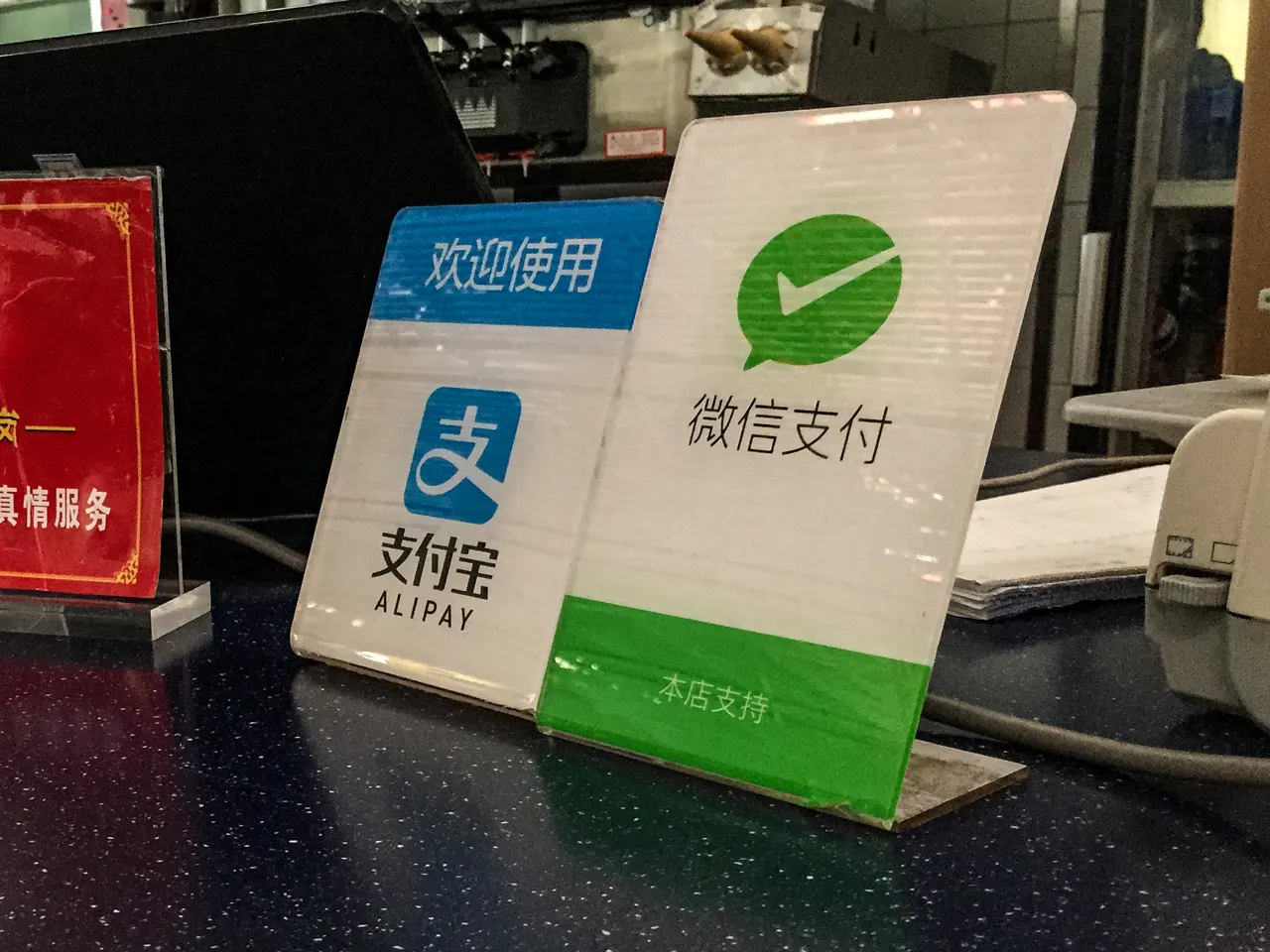 Таблички об оплате Alipay и WeChat Pay на стойке ресторана в Пекине
