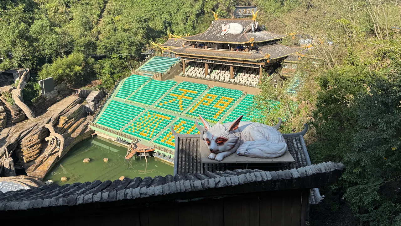 Asientos verdes y amarillos, filas traseras cubiertas y esculturas de zorros blancos en el teatro Tianmen Fox Fairy