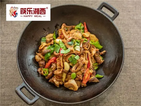 Sanxiaguo con carne e peperoncini verdi e rossi in una padella di ferro nera