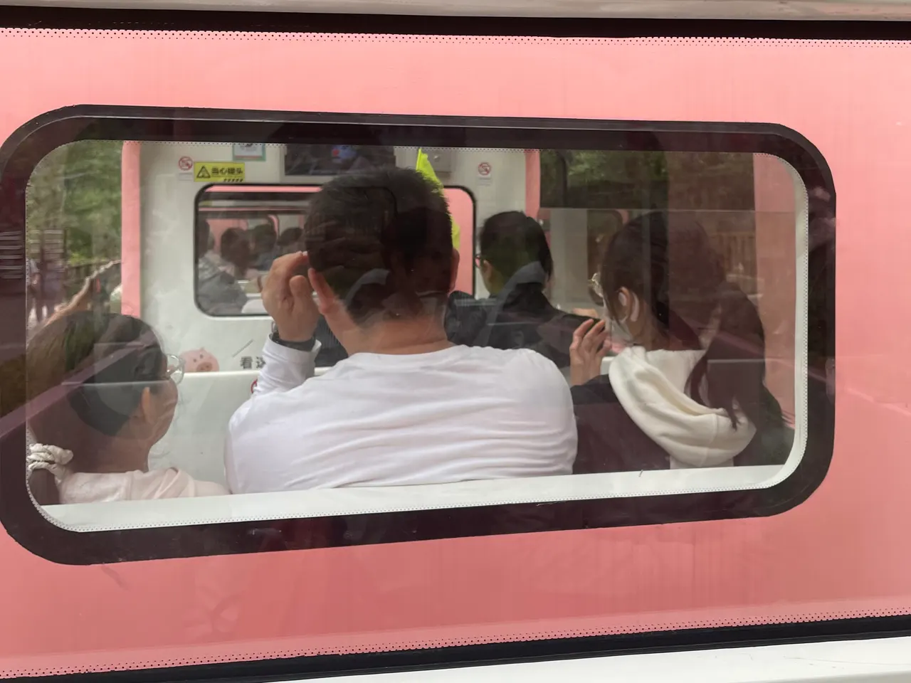 Passeggeri visti dal finestrino del trenino rosa della Galleria dei Dieci Li
