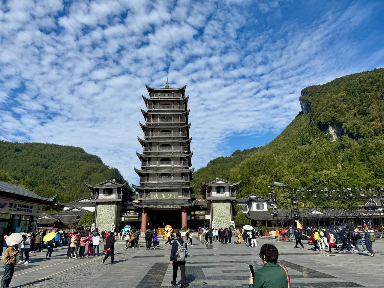 Visitantes en la plaza frente a la entrada este del parque forestal en Wulingyuan