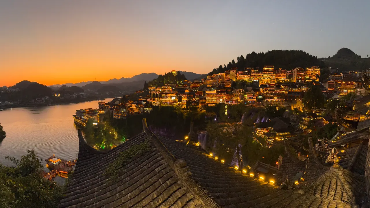 夕陽下的芙蓉鎮,亮燈建築、瀑布與河灣